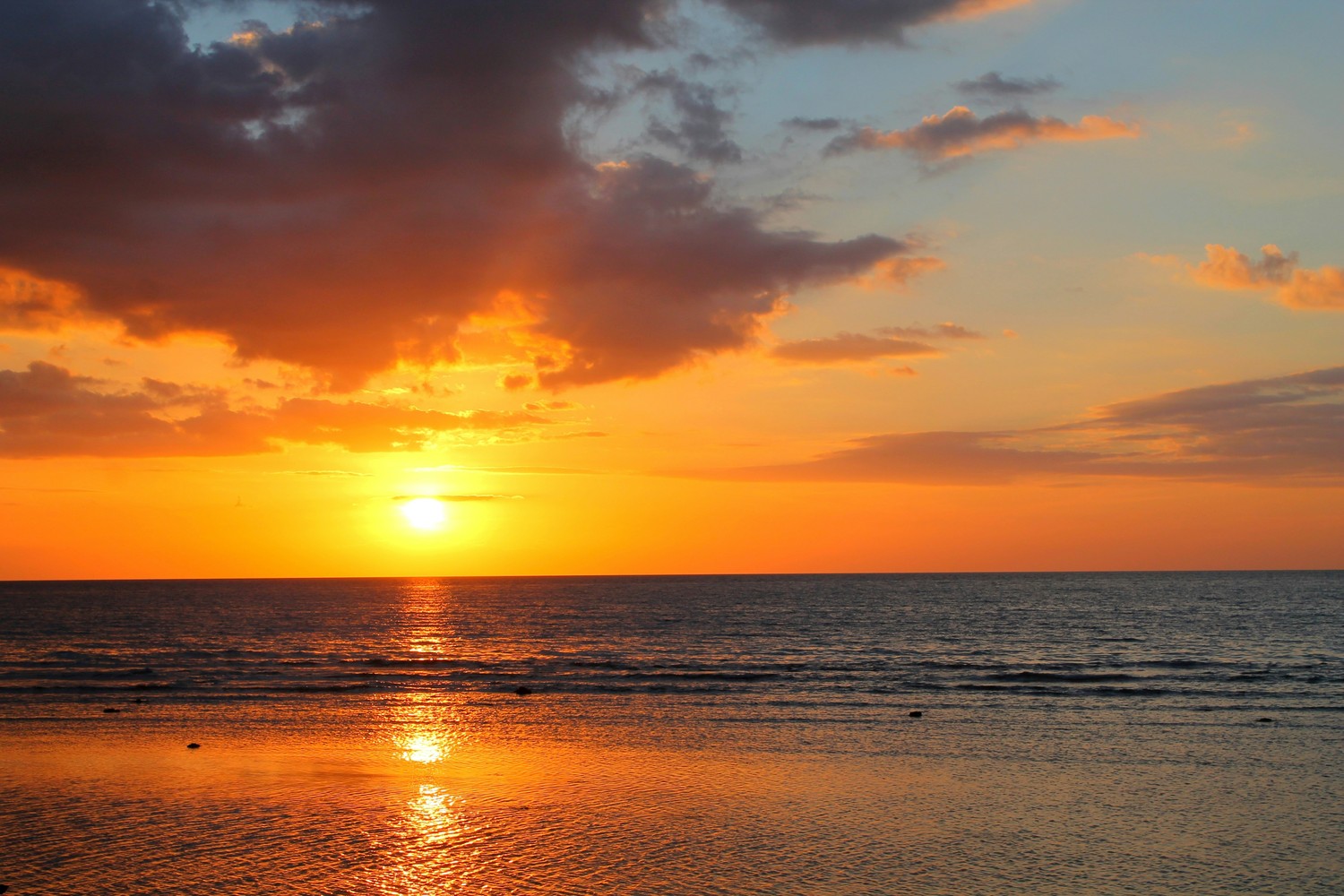Coucher de soleil orangé sur la mer depuis la côte nord de Bali