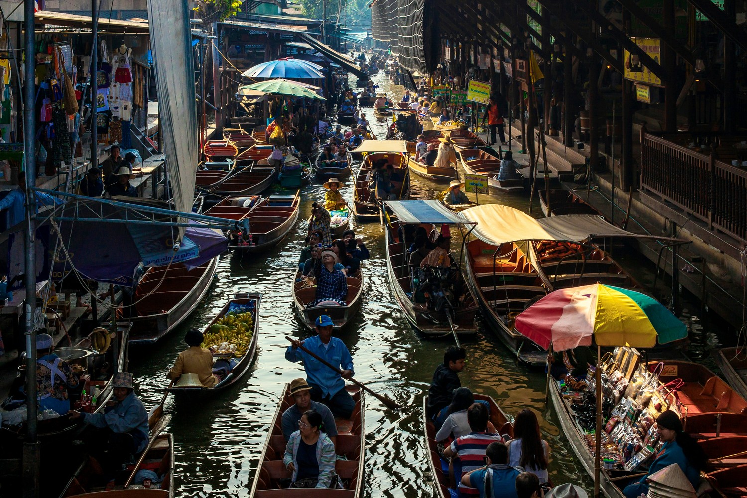 Barques de vendeurs serrées sur le canal d'un marché flottant thaïlandais
