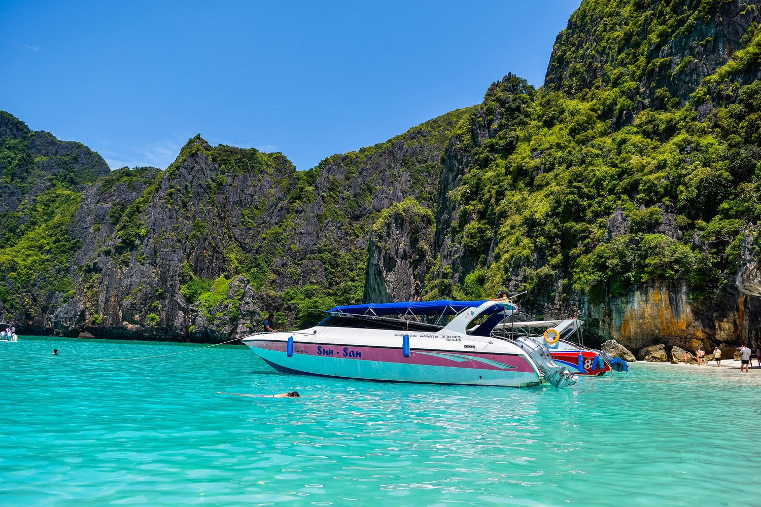 Speedboat d'excursion amarré près d'une plage, dans une eau turquoise