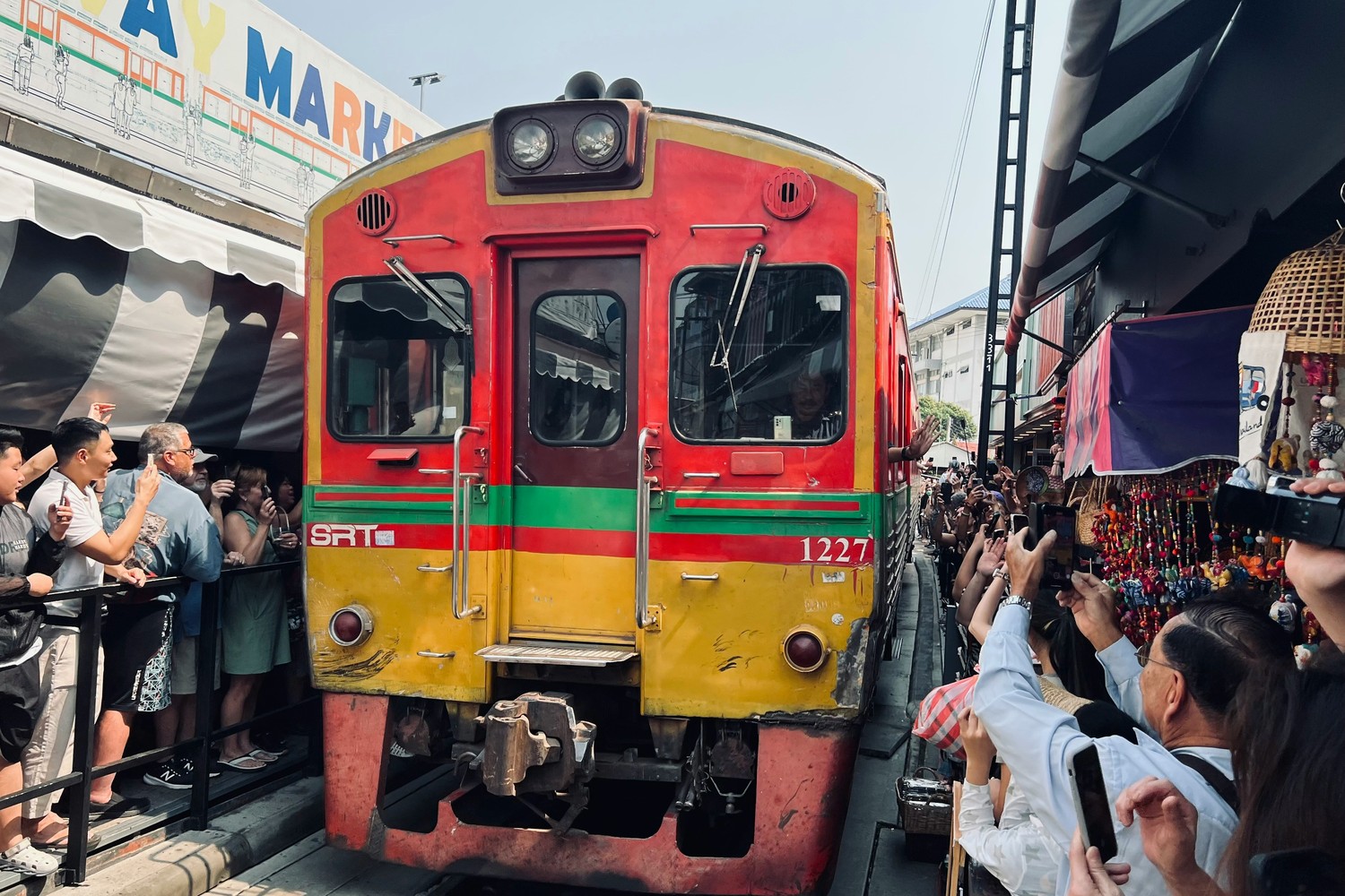 Train passant à quelques centimètres des étals du marché ferroviaire de Maeklong