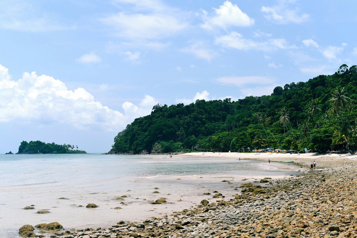 Rivage rocheux de Koh Chang découvert à marée basse, adossé à une colline couverte de jungle