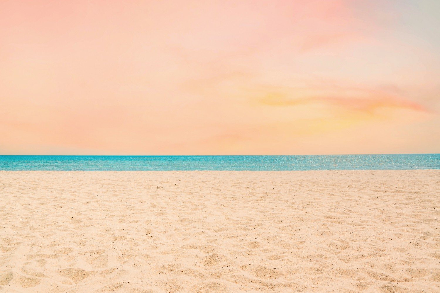 Plage de sable déserte au crépuscule, traces de pas et mer calme