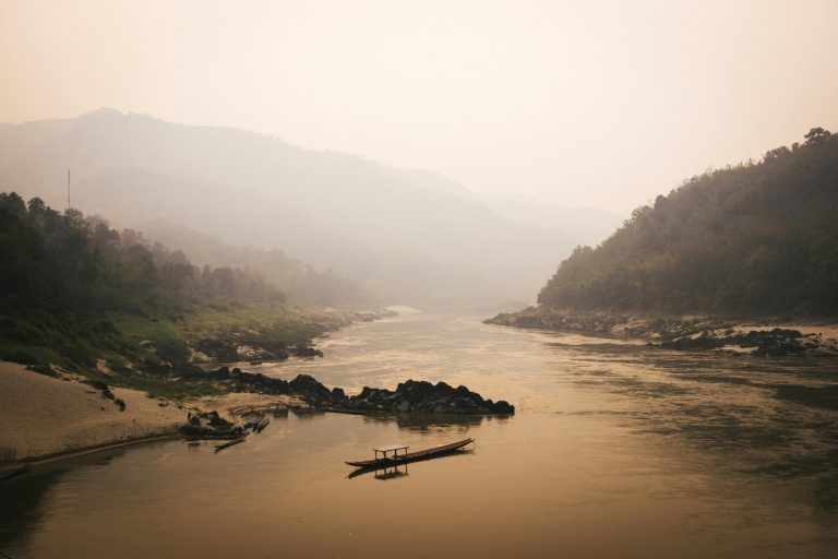 Le Mékong dans la brume avec une pirogue, Laos