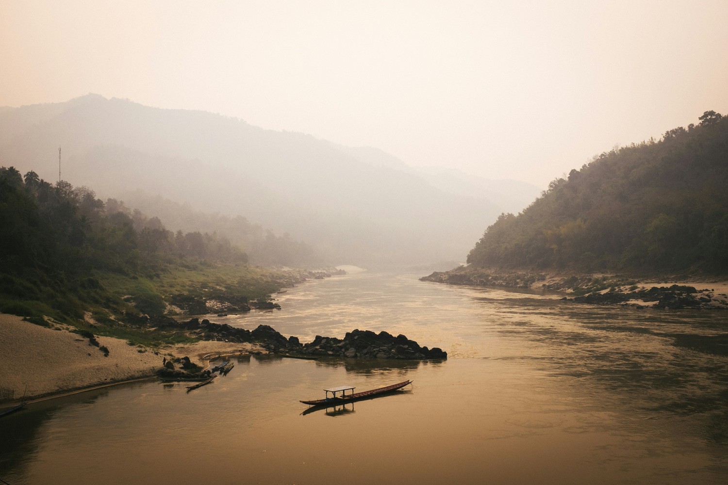 Le Mékong dans la brume avec une pirogue, Laos
