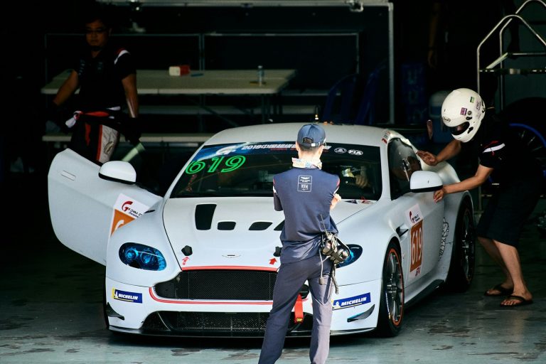 Voiture de course et mécaniciens dans les stands