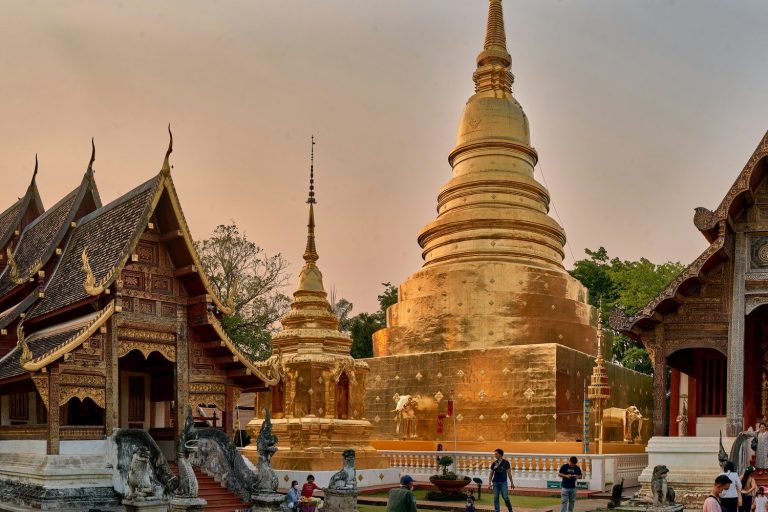 Le chedi dore et les viharns en teck du Wat Phra Singh a Chiang Mai en fin de journee