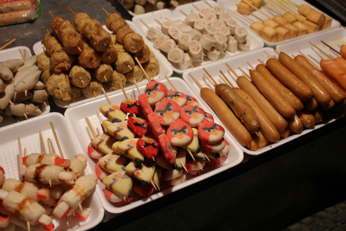 Brochettes de surimi, saucisses et pâtes de poisson sur les étals d'un stand du marché de nuit de Vientiane.