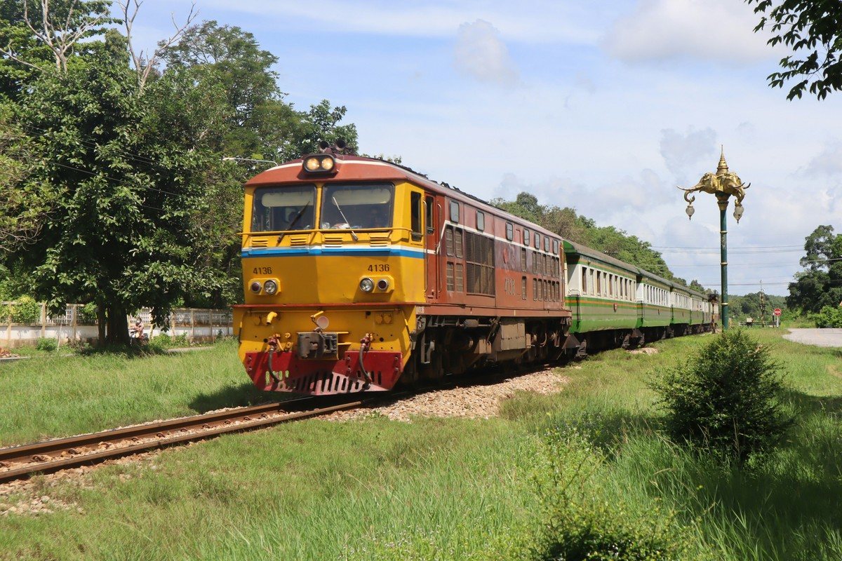 Train de la State Railway of Thailand en rase campagne, locomotive orange en tête